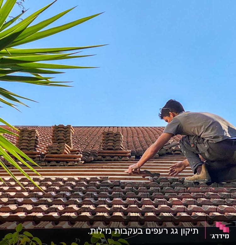 אדם עובד על גג רעפים עם כלים